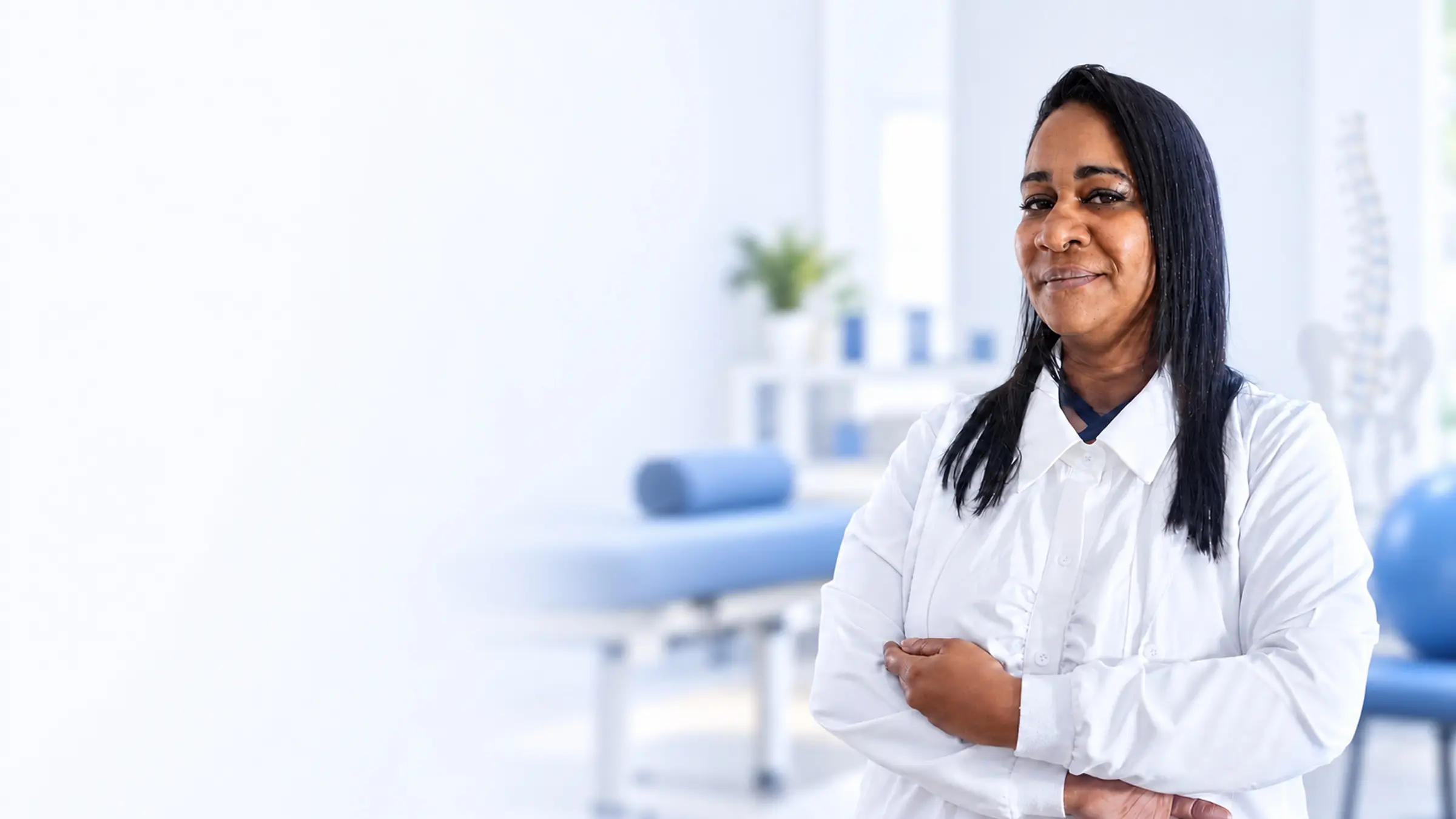 Dra. Raisa Braz, fisioterapeuta, de jaleco no consultório